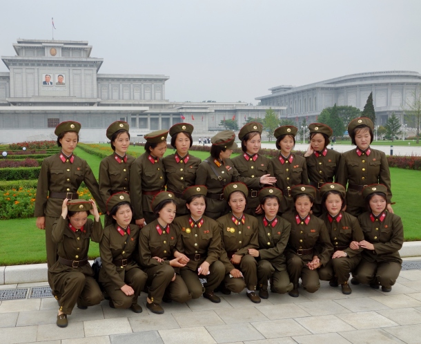 A group of soldiers prepare themselves for a group picture in front of the mausoleum housing Kim Il-sung and Kim Jong-Il  